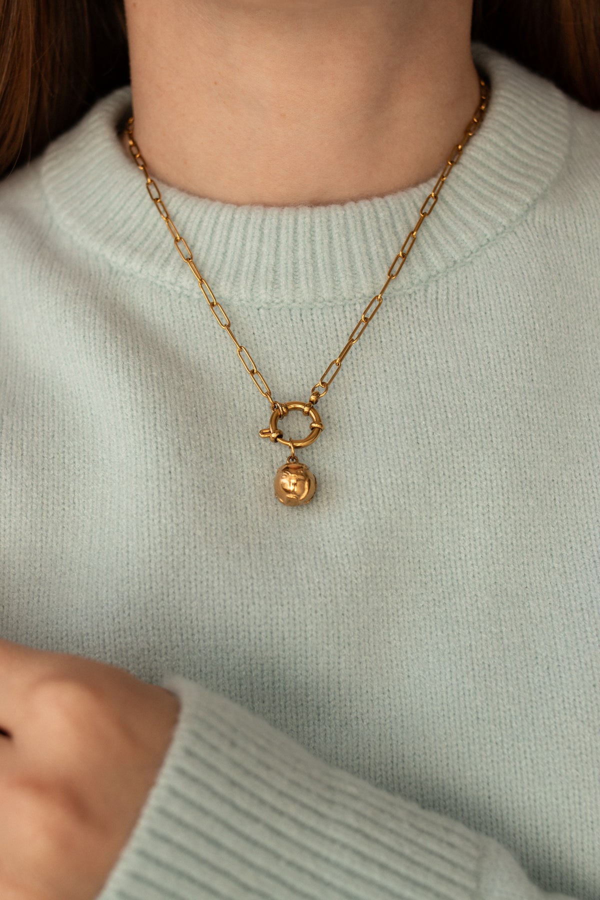 Tiny World Charm worn on a gold chain