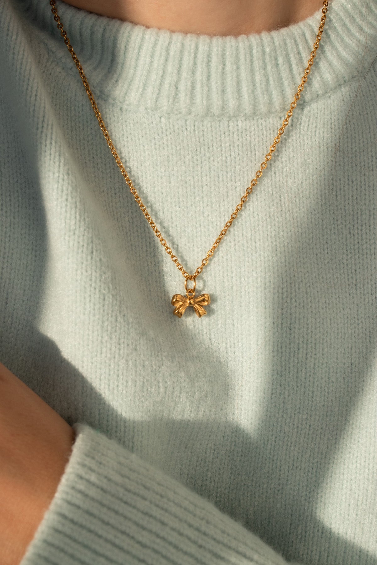 Little Bow Charm worn on a gold rope chain